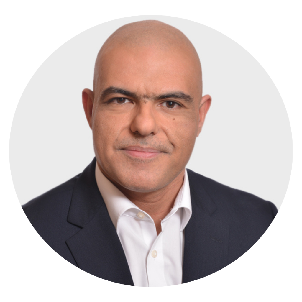 Professional headshot of a bald man in a dark suit and white shirt, facing the camera with a neutral expression.