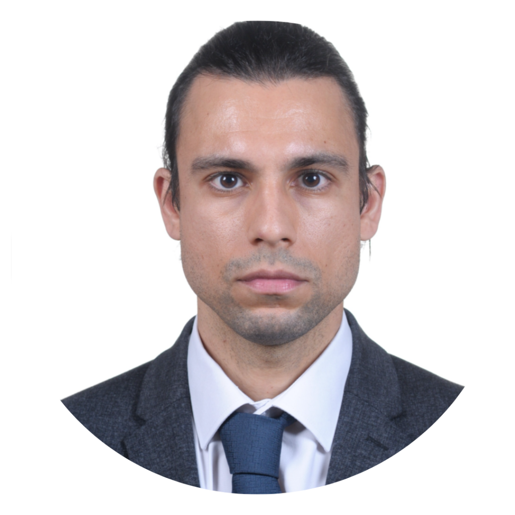 Professional headshot: man in a dark suit and blue tie, neutral expression, white background, circular crop.